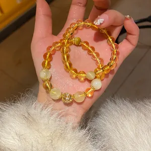 Close-up of elegant citrine and moonstone beaded bracelets held in a hand model