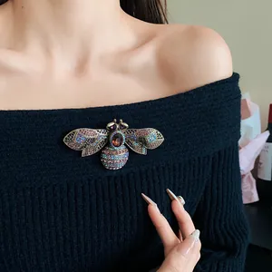 Vintage bee brooch with colorful rhinestones pinned on a black off-shoulder sweater