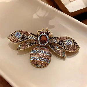 Detailed view of a vintage bee brooch featuring colorful rhinestones and a gold-tone finish.