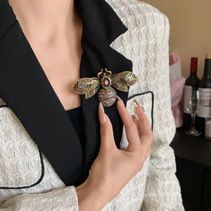 Close-up of a vintage luxury bee brooch with multi-colored crystal embellishments.