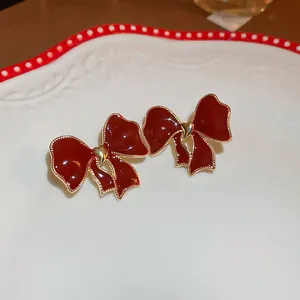 Vintage burgundy bow stud earrings with gold heart detail and 925 silver needles
