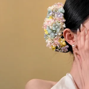 Dettaglio macro di un fermaglio per capelli con fiori di stoffa pastello