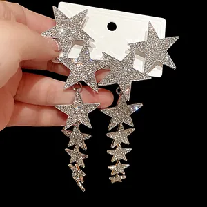 Detailed close-up of sparkling silver rhinestone star tassel earrings on a white display card