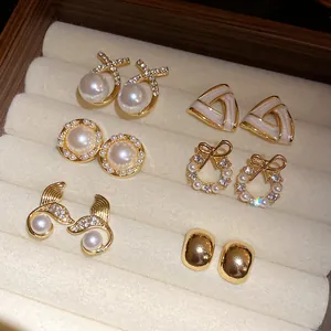 Close-up of a French retro earring set with pearls and rhinestones in a display box