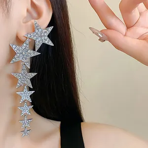 Close-up of long silver star tassel earrings with shimmering rhinestones for women