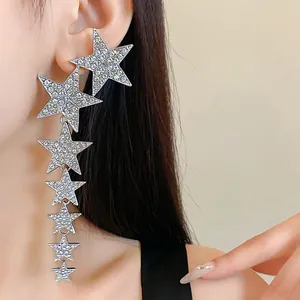 Close-up of elegant sparkling rhinestone star tassel drop earrings worn on a model's ear