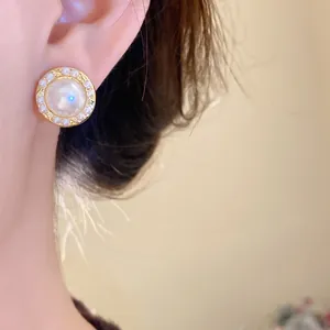 Detailed close-up showing an elegant vintage pearl stud earring with gold frame worn on ear