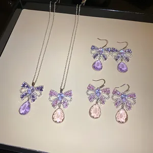 Elegante Zirkon-Bogen-Halsketten und Tropfen-Ohrringe mit lila Kristallen im Set.