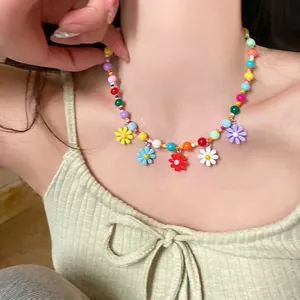 Colorful acrylic bead necklace with vibrant daisy flower charms worn by a model.