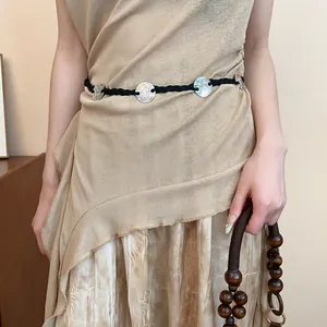 Close-up of bohemian ethnic braided waist chain featuring engraved silver metal discs