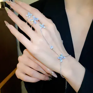 Vista dettagliata di un elegante bracciale ad anello integrato con farfalla in zircone su mano.
