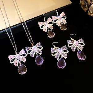 Detailansicht des luxuriösen Zirkon-Schleifen-Schmucksets mit lila Kristalldrops.