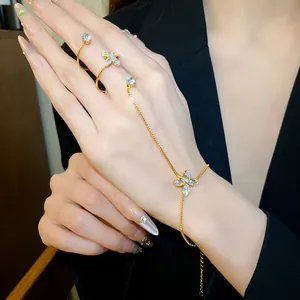 Primo piano di un elegante bracciale a dito in oro con fiore in zircone e anello.