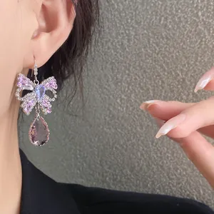 Detailansicht von eleganten Schmetterlings-Ohrhängern mit Zirkonia und lila Kristall