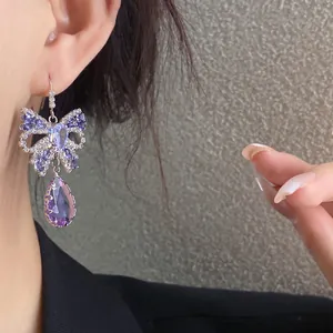 Detailansicht der luxuriösen lila Zirkon Schmetterling Ohrringe mit Tropfenanhänger