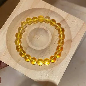 Bracciale in perle di agata gialla di alta qualità su supporto in legno naturale