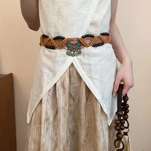 Close-up of Bohemian hand-woven hemp rope waist chain with dark wood beads and metal coins