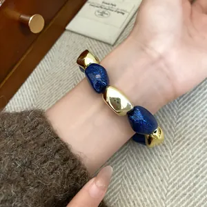 Dettaglio ravvicinato del bracciale elastico in acrilico vintage blu glitter e oro