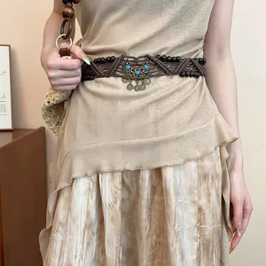 Close-up of a Bohemian woven waist belt featuring turquoise beads and metal pendants