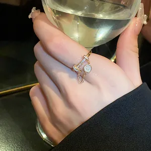 Elegant gold-tone T-bar ring featuring pavé zircon charm and delicate chain details.