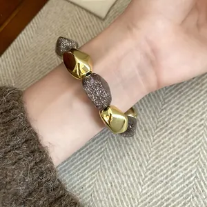 Vista dettagliata delle perle in acrilico dorate e glitterate di un bracciale vintage