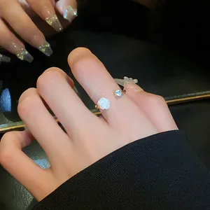 Close-up of elegant open ring featuring a white rose flower and sparkling zircon