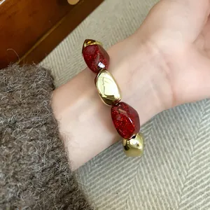 Vista dettagliata di un braccialetto elastico retrò in acrilico con glitter rossi.