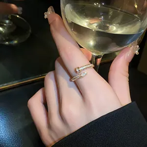 Close-up of a gold-toned open nail ring with shimmering zircon pave on a finger