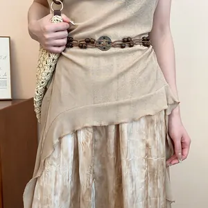 Detail of Bohemian ethnic braided hemp rope belt with wooden beads and round buckle