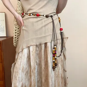 Detailed view of bohemian braided waist chain with colorful wooden beads on dress