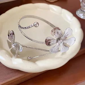 Elegante bracciale rigido a fiori in argento con strass su un piatto in ceramica decorato