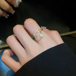 Close-up of an elegant gold zircon open ring featuring a horizontal bar and chain charm