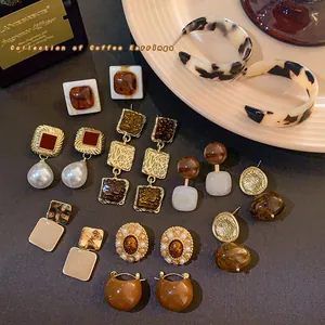 Vue détaillée d'une collection de boucles d'oreilles vintage café avec perles et touches résine