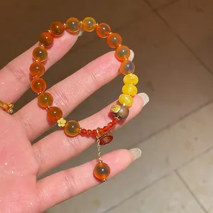 Detailed shot of New Chinese style orange agate bracelet with gold flower charm