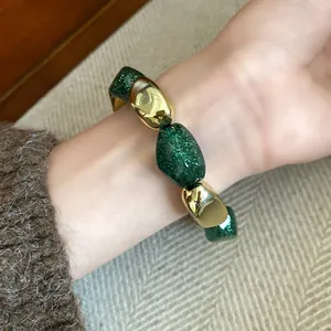 Primo piano di bracciale elastico retrò con perle acriliche verdi glitterate e dorate