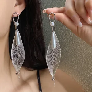 Orecchini a sospensione in maglia con perle su un elegante modello asiatico di lusso.