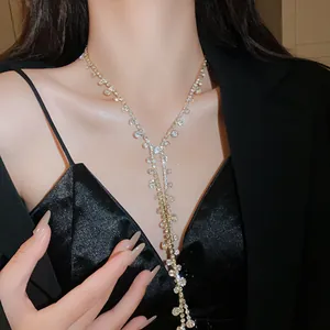Close-up detail showing a sparkling rhinestone Y-shaped lariat tassel necklace on a model.
