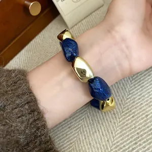 Primo piano di un elegante bracciale elastico vintage con perline acriliche blu e dorate