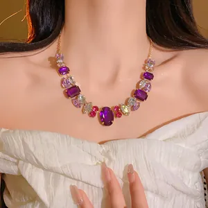 Close-up detail of a vintage style gold-tone necklace with purple and pink faceted crystals