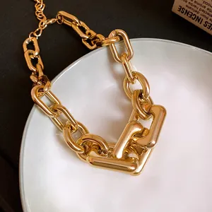 Macro view showing the polished gold finish and chunky links of this punk style metal chain necklace