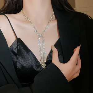 Close-up of sparkling rhinestone tassel necklace worn on an elegant black outfit