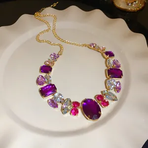 Detailed view of a vintage luxury gold necklace with assorted purple and pink faceted gemstones