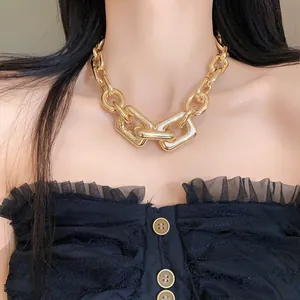 Macro detail of chunky gold-tone metal chain necklace with geometric interlocking links
