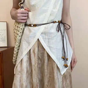 Detail shot of a Bohemian braided rope waist chain with decorative wooden beads