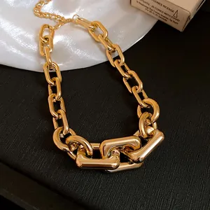 Close-up detail view of a bold gold chunky chain necklace featuring interlocking metal links