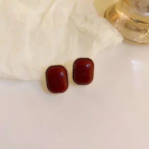 Close-up detail of vintage brown resin stud earrings featuring a gold twisted rope border