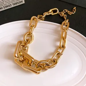 Detailed macro view of the chunky gold-toned necklace with interlocking U-shaped chain links
