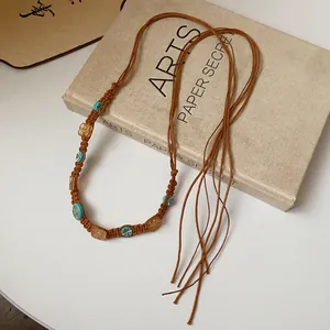 Close-up detail view of Bohemian woven waist chain with turquoise beads on hemp rope