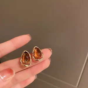 Détail de boucles d'oreilles vintage marron en forme de goutte avec cadres dorés