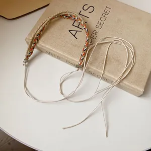 Bohemian woven braided waist chain belt with ethnic pattern on vintage book background